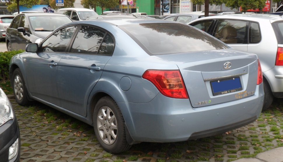 Rear side view of a blue sedan with distinct rear lights and tinted windows.