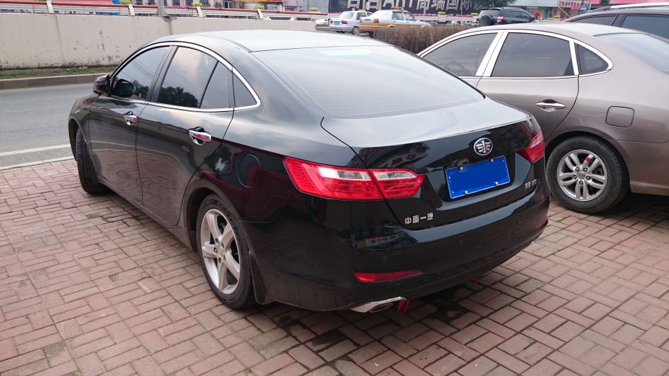 Rear side view of black sedan with distinct taillights and alloy wheels