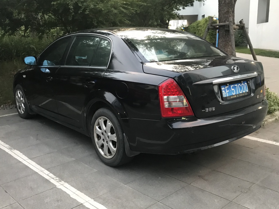 Rear and side view of black sedan with distinctive tail lights and alloy wheels