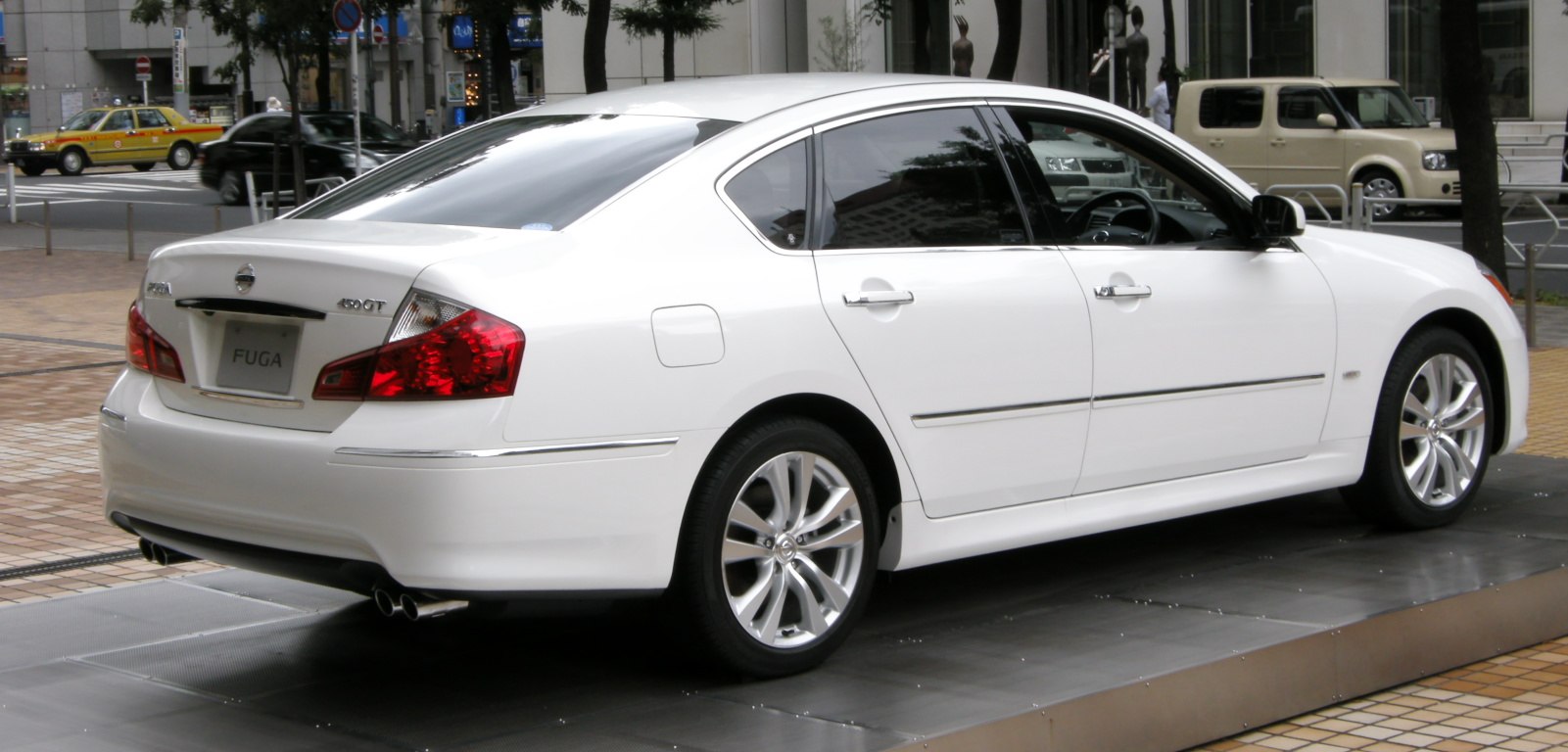 Rear and side view of white sedan with alloy wheels and distinctive taillights