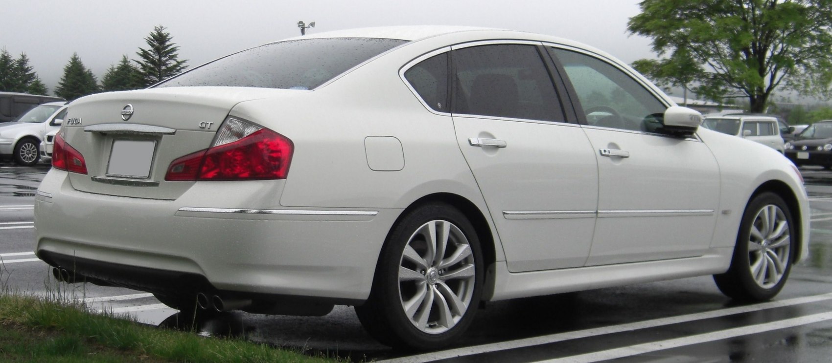 Rear side view of a luxury sedan with alloy wheels and quad exhaust