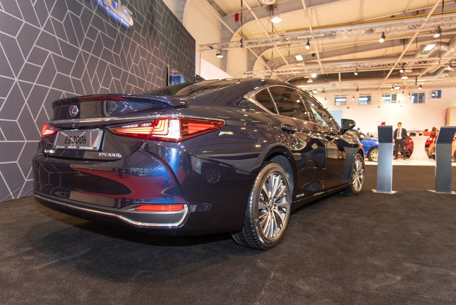 Rear view of a luxury hybrid sedan with sleek taillights and polished alloy wheels