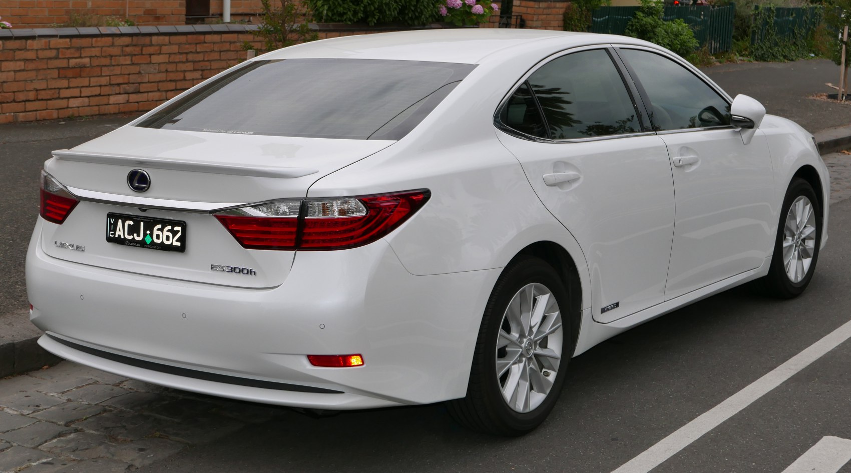 Rear side view of sedan with distinct taillights and hybrid badge