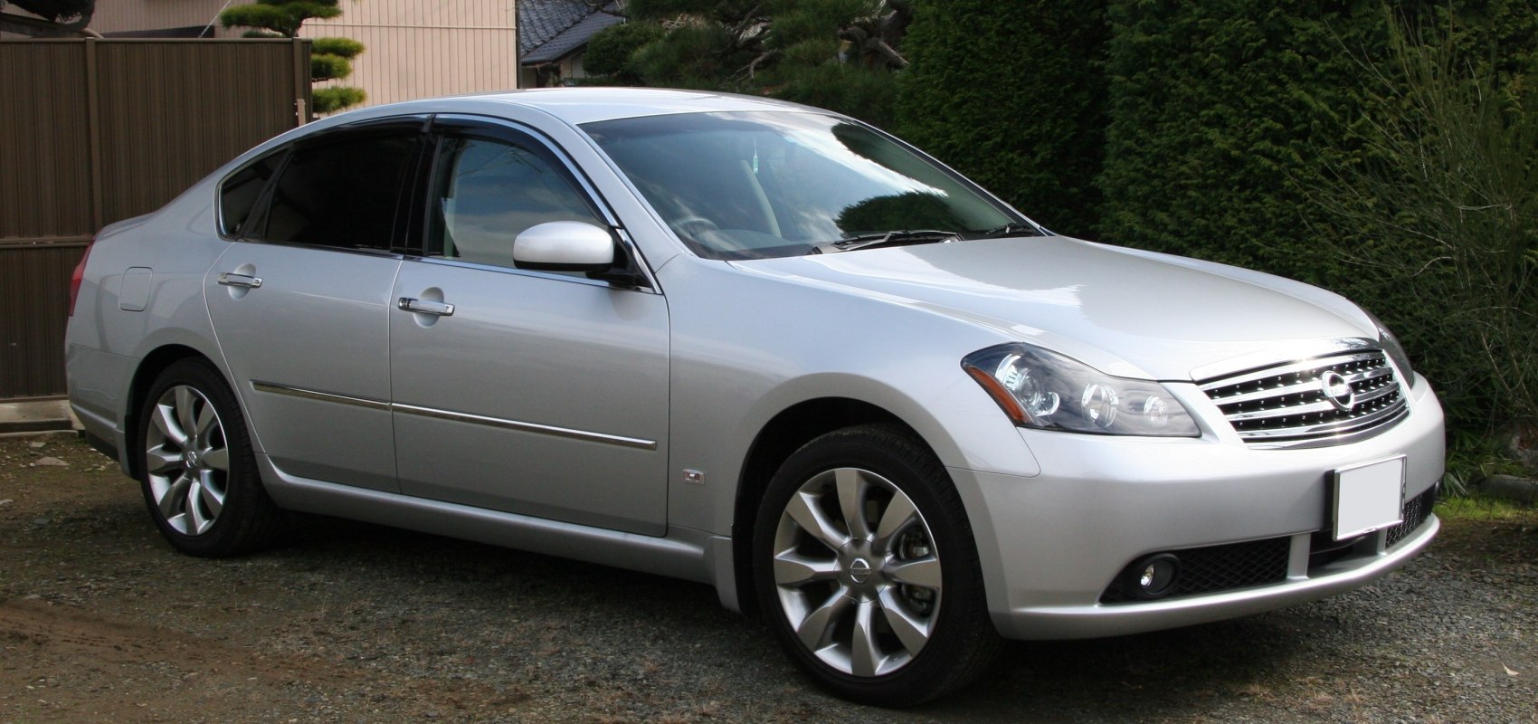 Silver sedan front-side view with alloy wheels and sporty design.