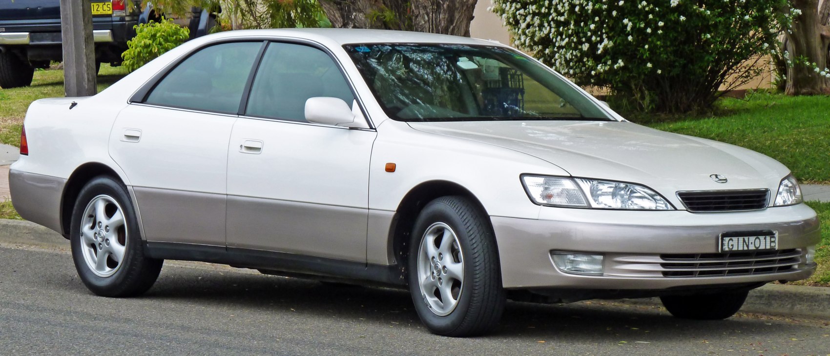Front-side view of a dual-tone painted sedan with alloy wheels.