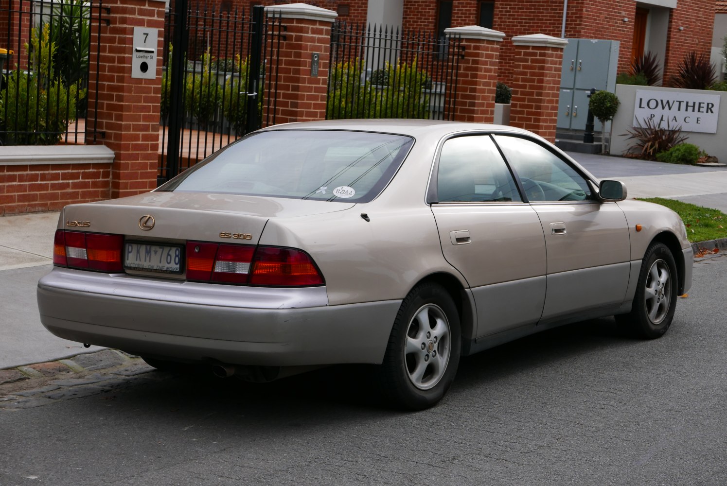 Rear side view of a classic mid-90s sedan with distinct taillights and smooth body lines.
