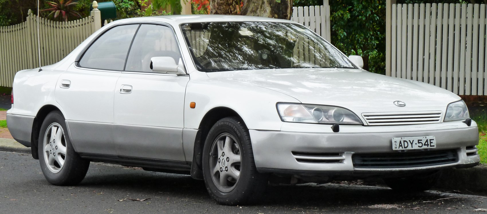 Front-side view of a classic mid-90s sedan with smooth lines and distinctive headlights.