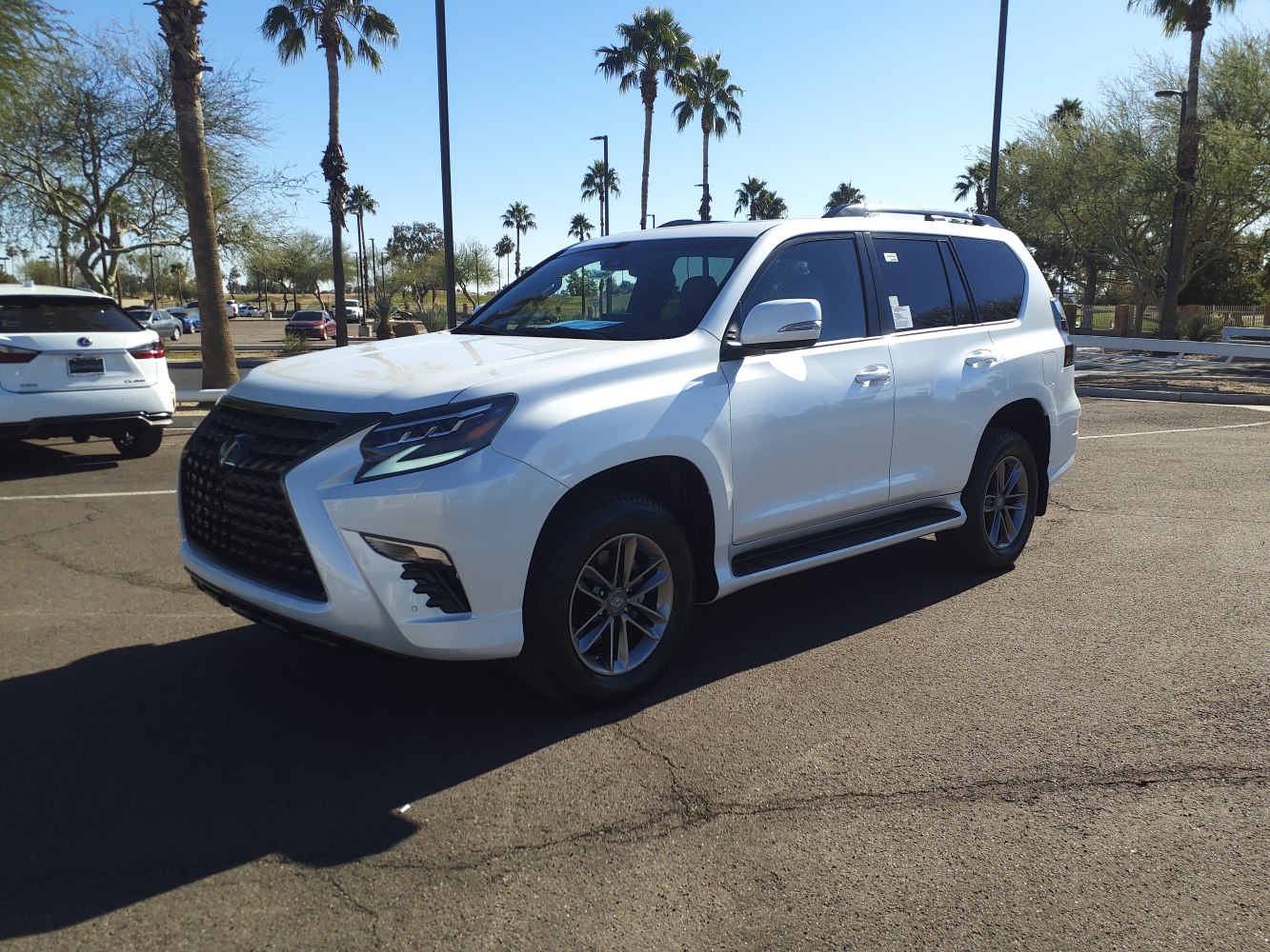 White SUV with modern headlights, prominent grille, side steps