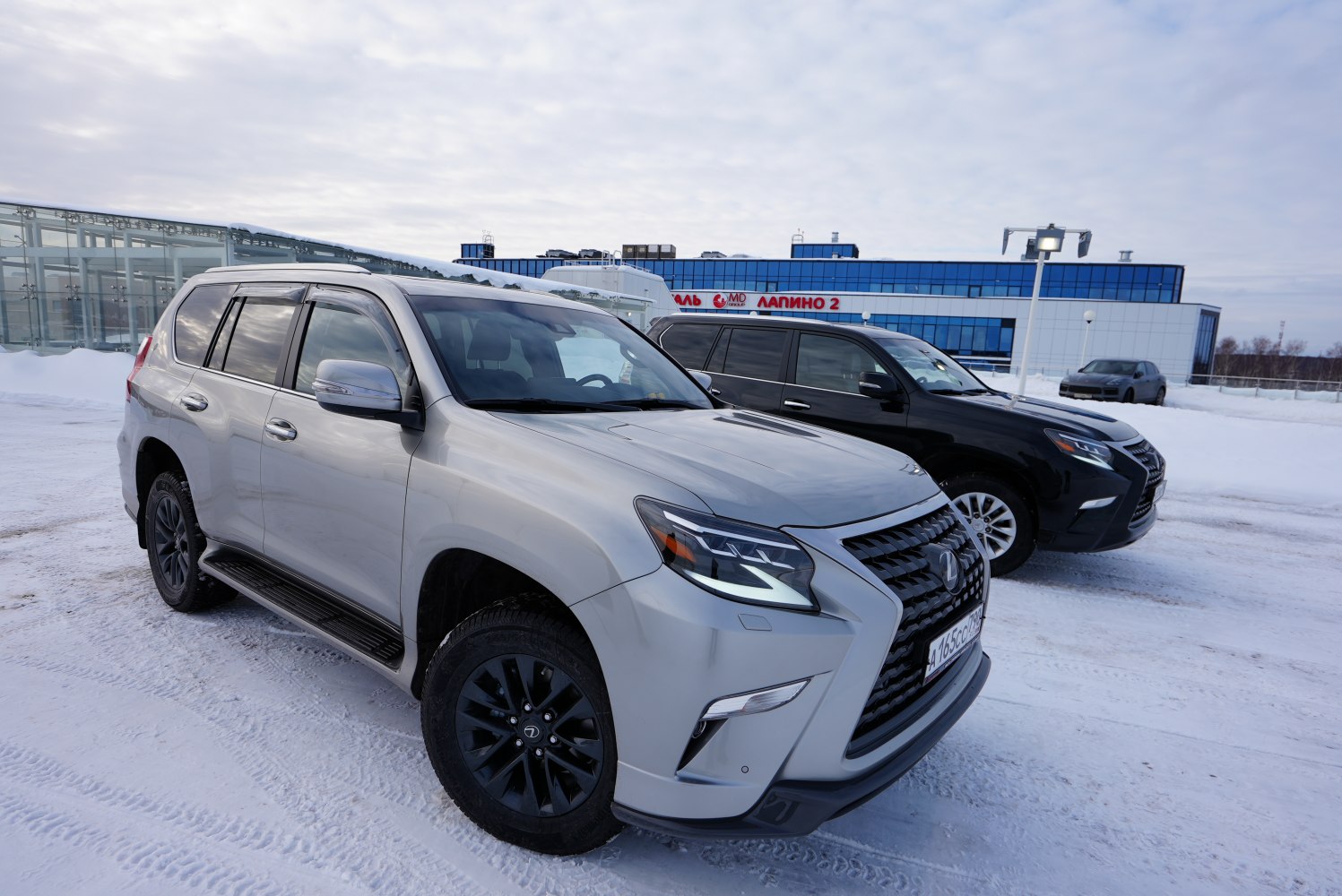 Front and side view of rugged SUV with LED headlights and black rims in snow