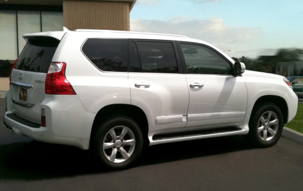 White large SUV with dark tinted windows and side steps.