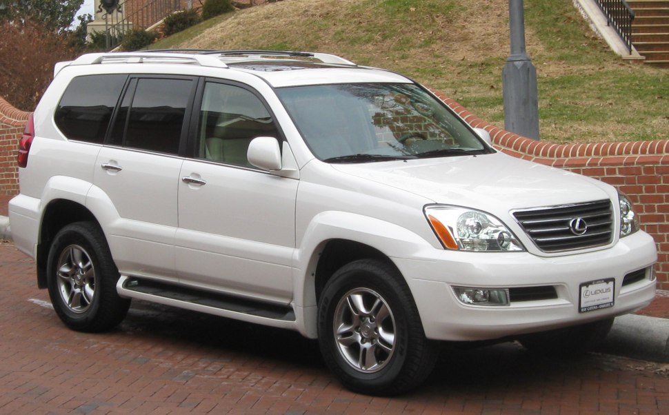 Front side view of a white mid-size SUV with roof rails and alloy wheels