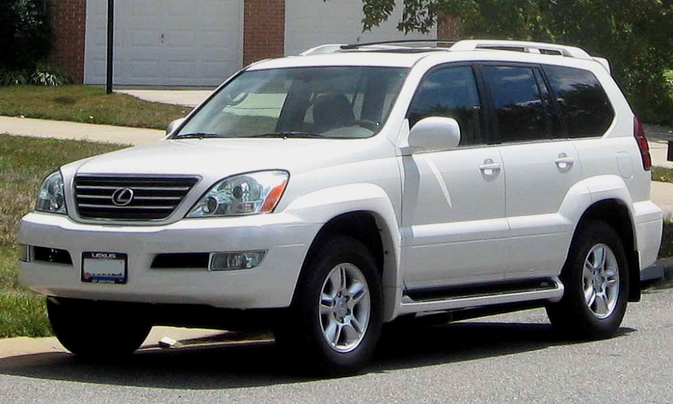 Front-side view of white mid-size SUV with rugged body contours and roof rails