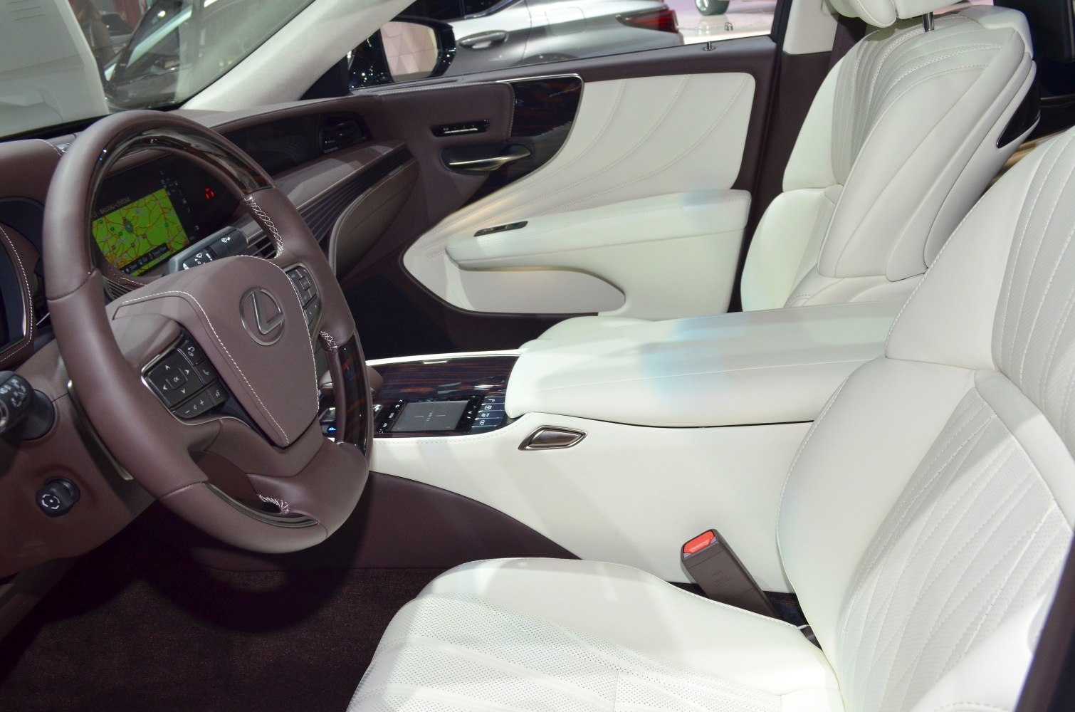 White leather seats and brown steering wheel with integrated controls.