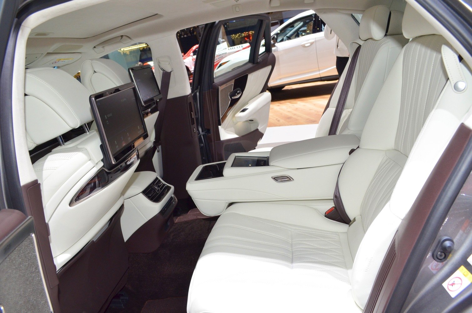 Rear interior with white leather seats and dual screens