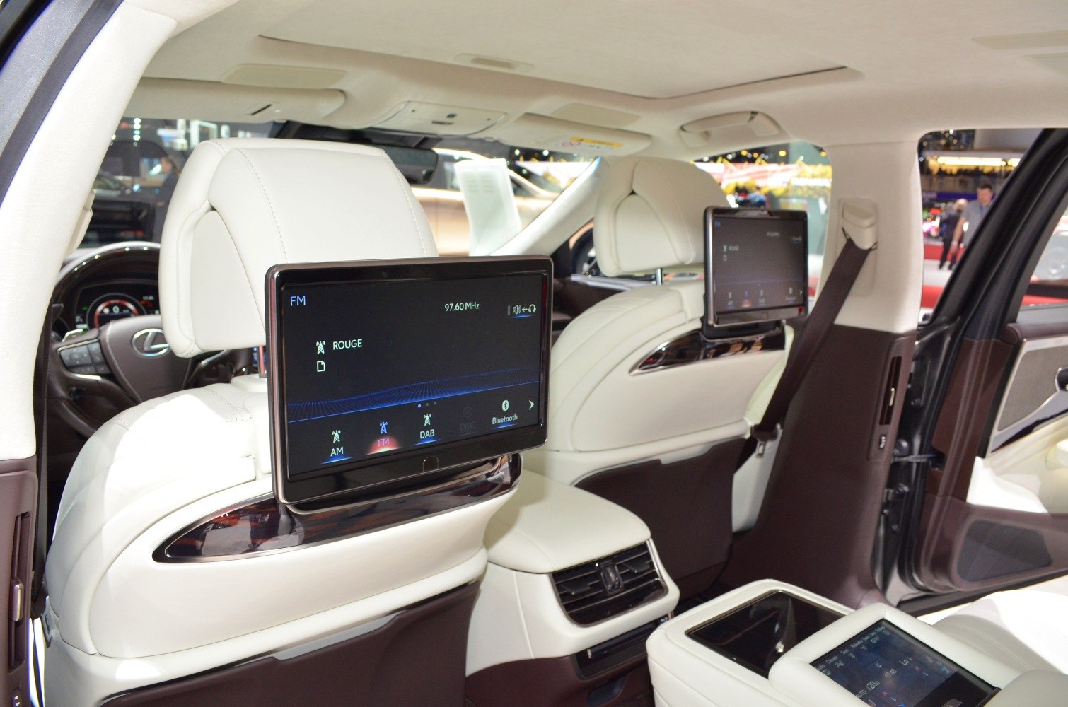 Luxury rear seat entertainment system with dual screens and premium white leather interior