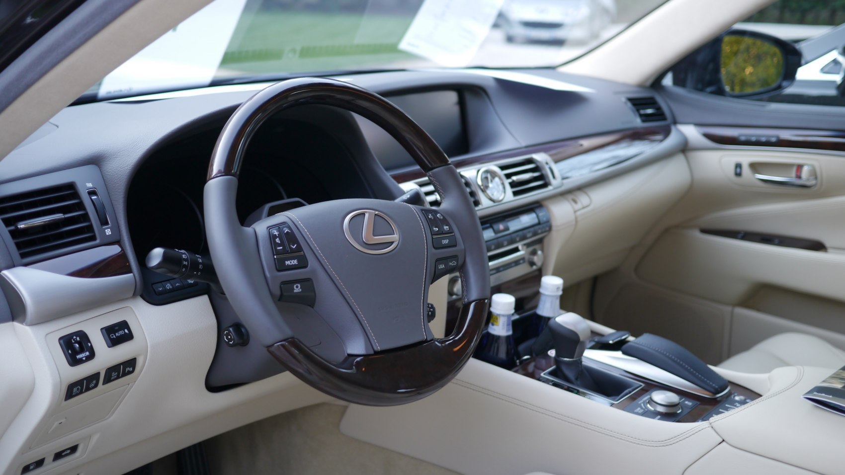 Luxury steering wheel and detailed dashboard interior with wood trim and controls