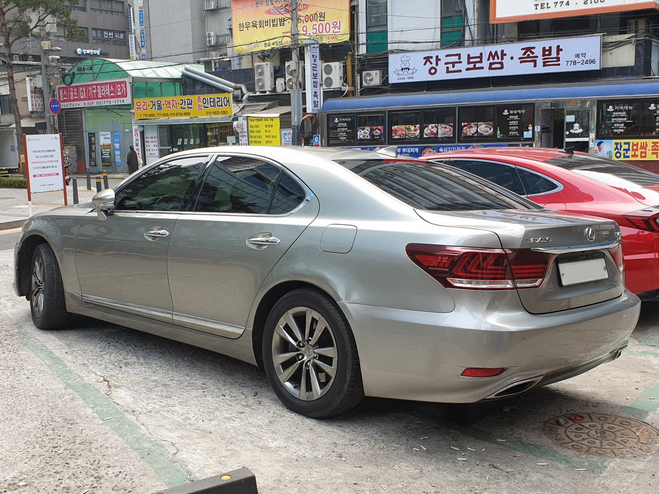 Rear side view of silver luxury sedan with alloy wheels and distinct taillights.