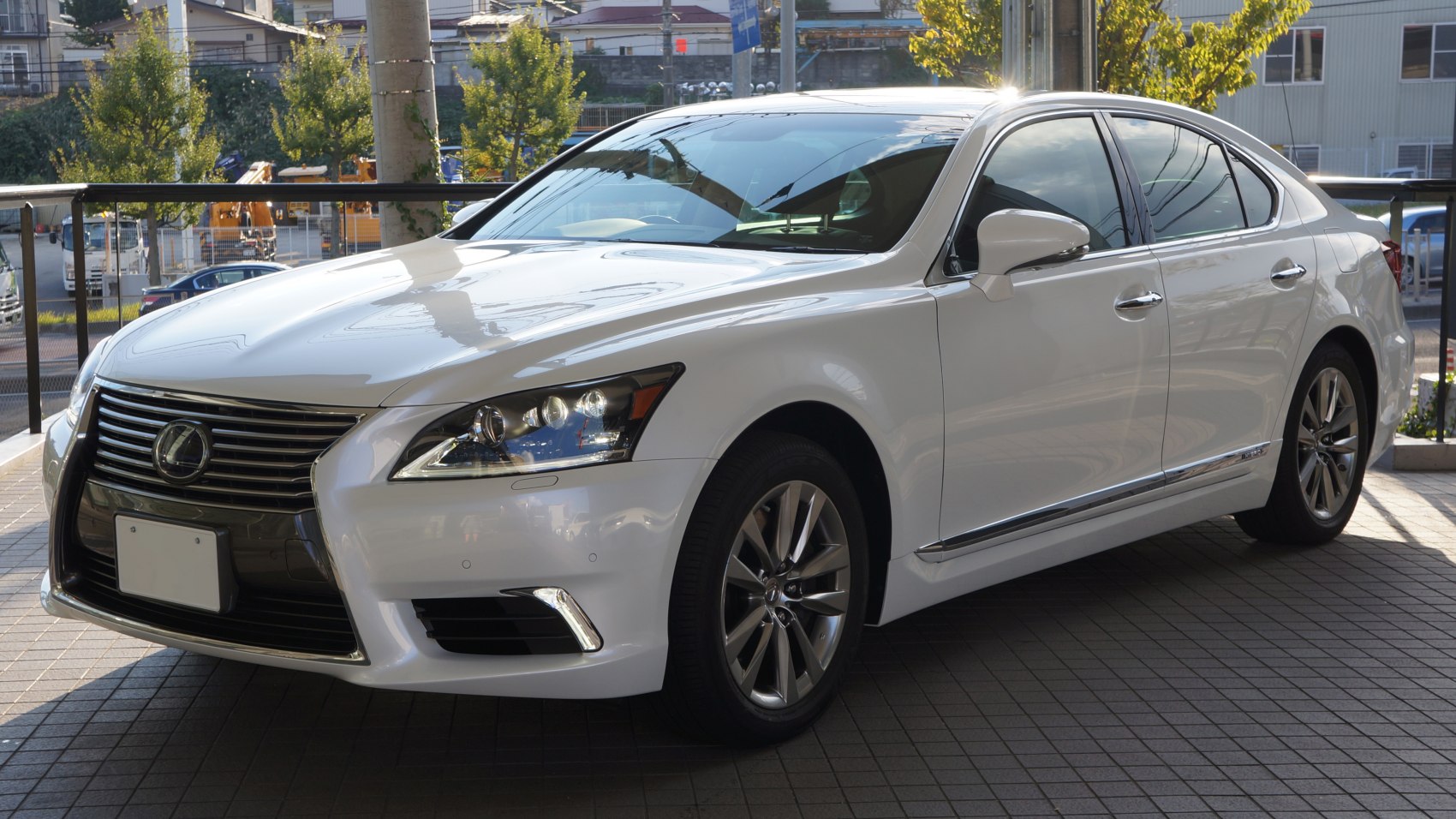 Front-side view of white luxury sedan with signature grille and headlights