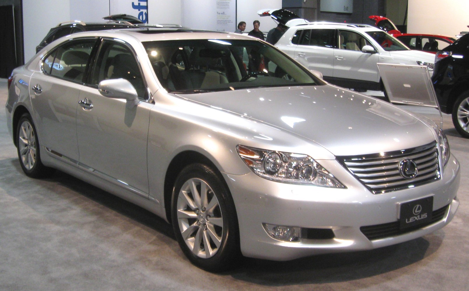 Front side view of luxury sedan with sleek headlights and chrome grille.