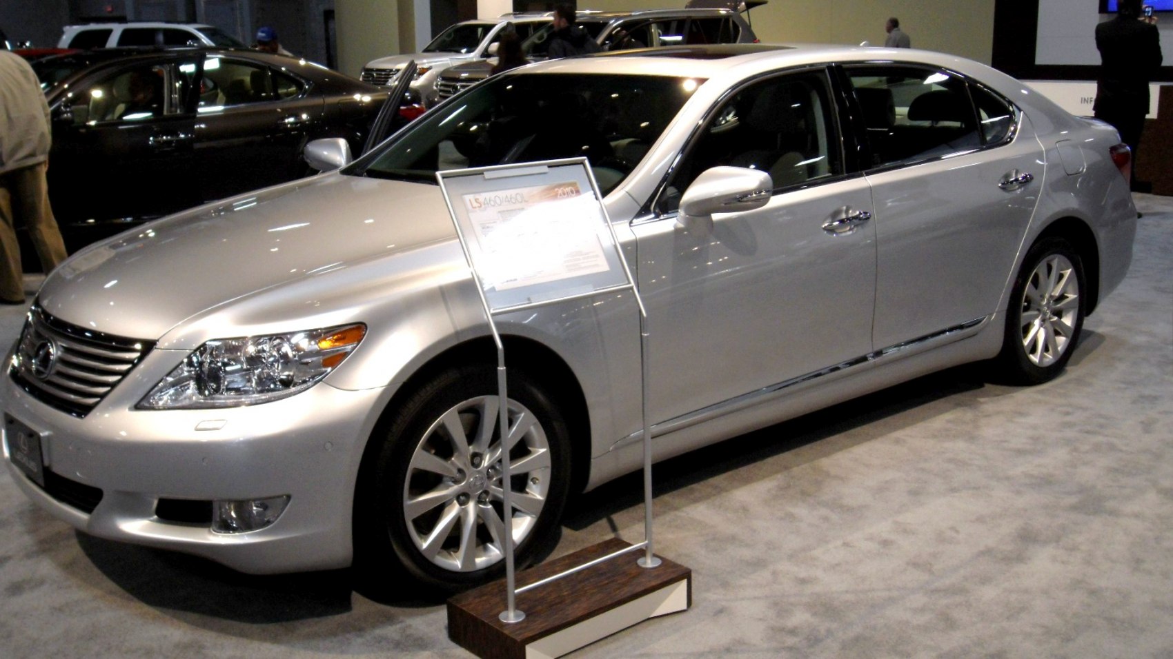 Luxury sedan front side and wheel design in a showroom setting