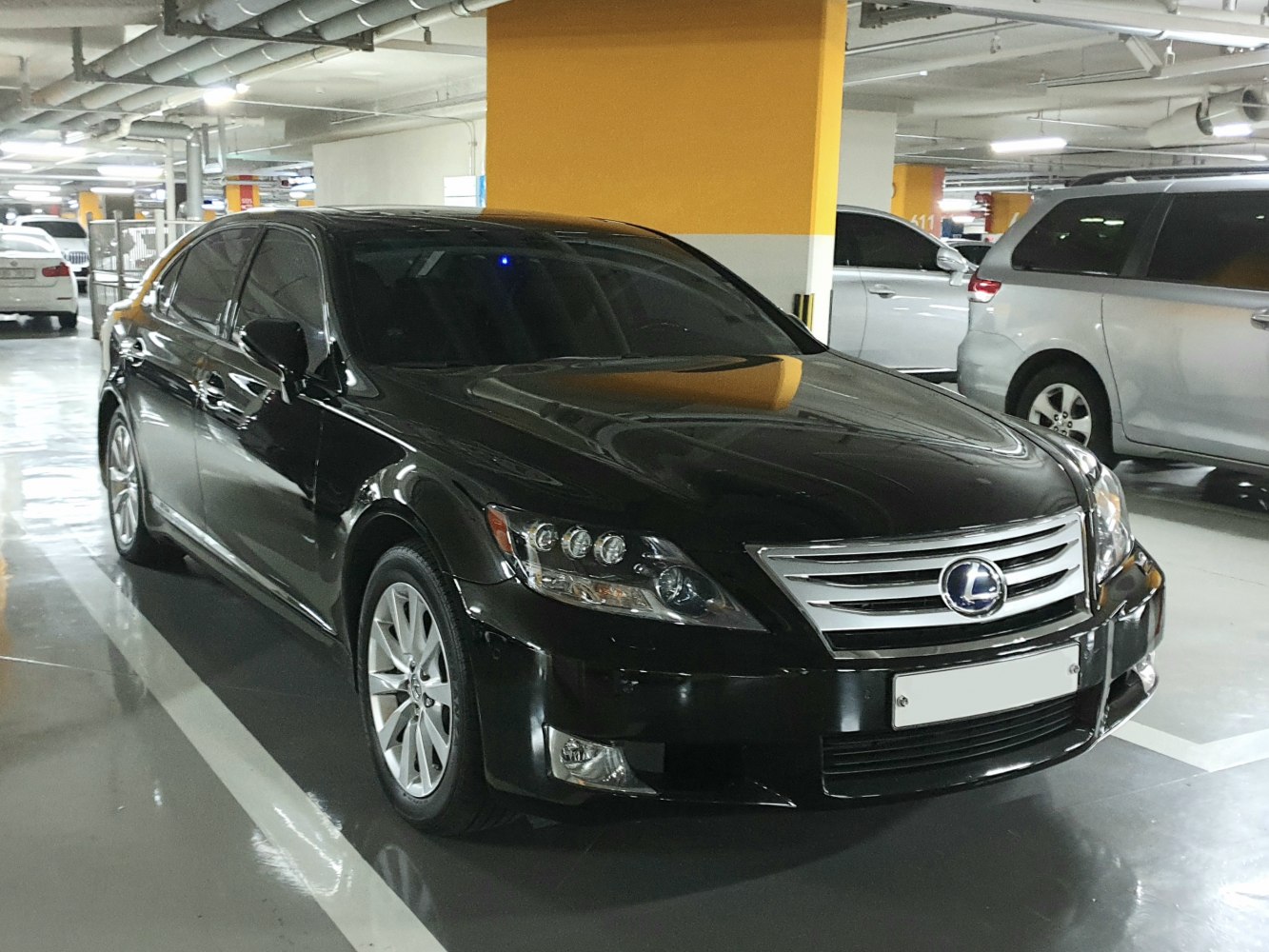 Front side view showing headlight design and grille of a luxury sedan.