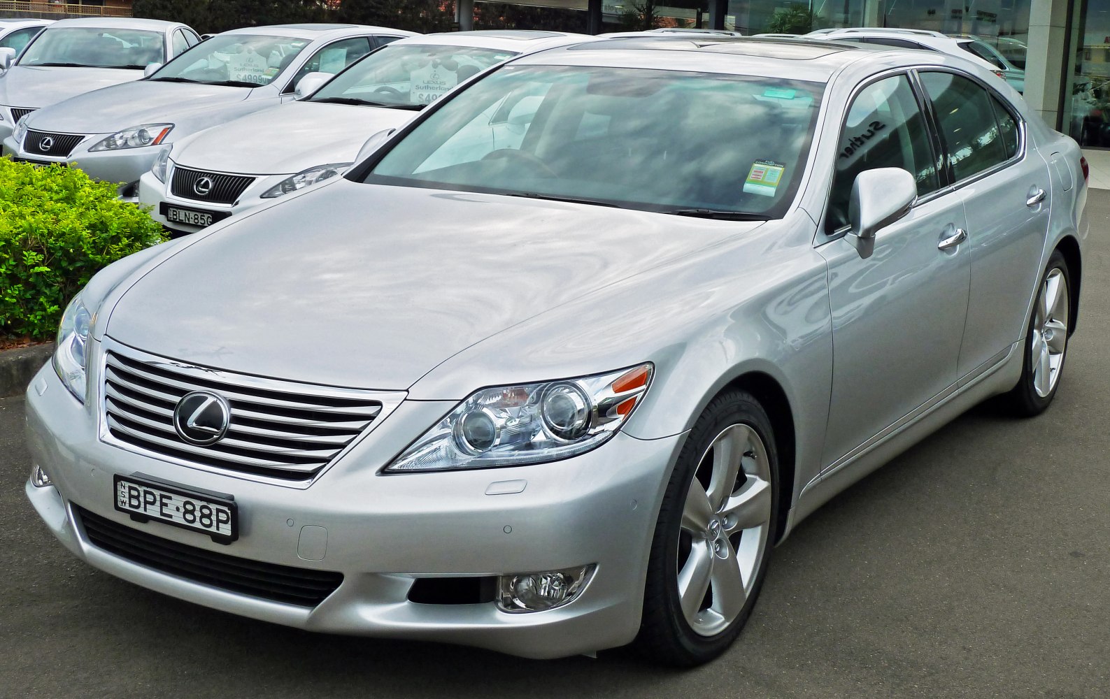 Silver luxury sedan with dual projector headlights and signature front grille