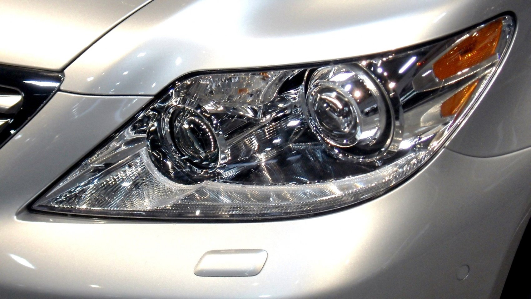 Close-up of multi-reflector projector headlight with amber turn indicator
