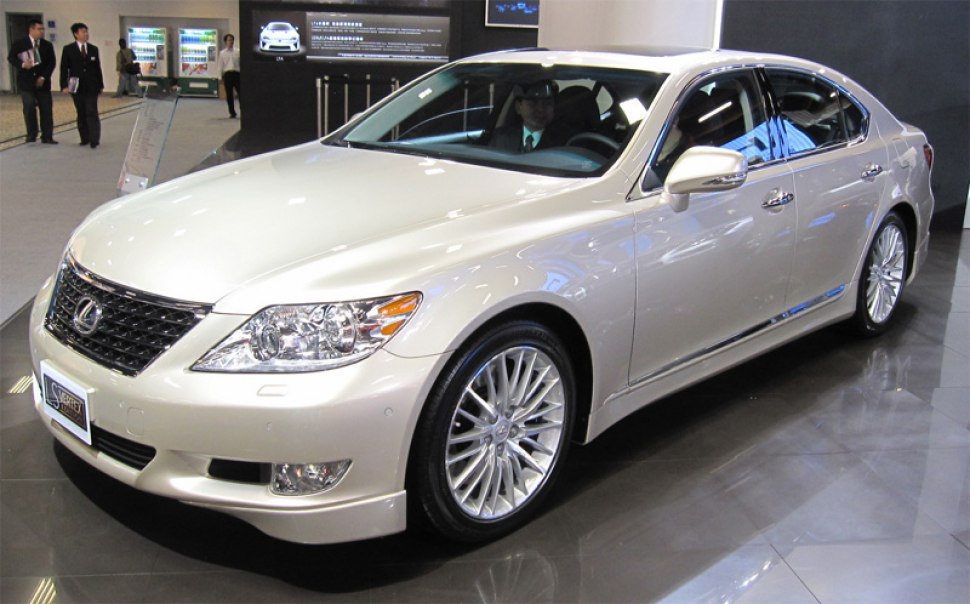 Luxury sedan with front grille and multi-spoke alloy wheels.