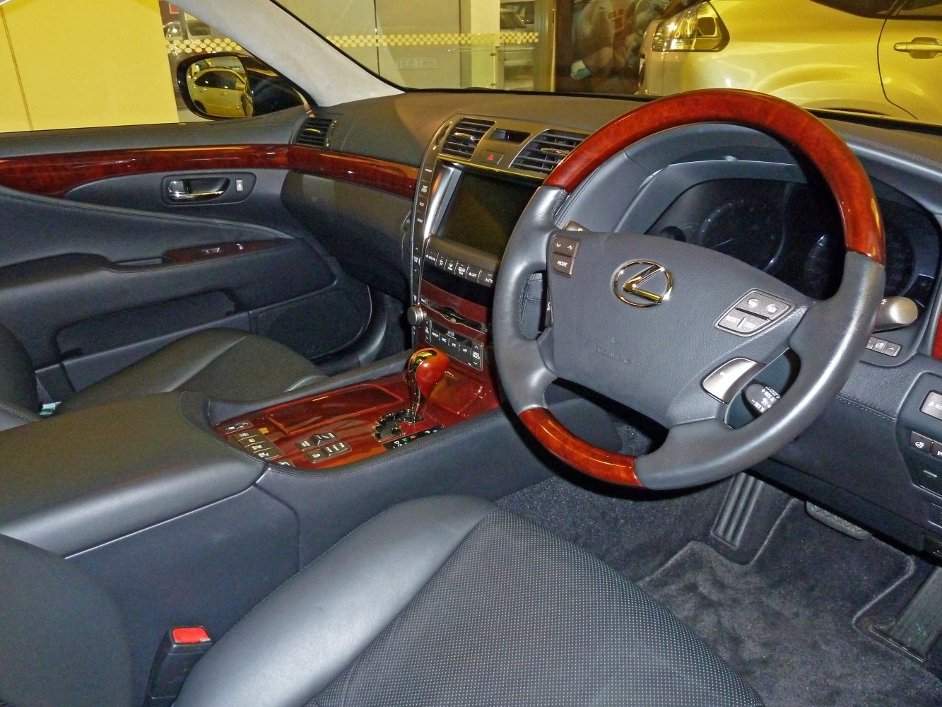 Luxury car interior with wood trim steering wheel and leather seats