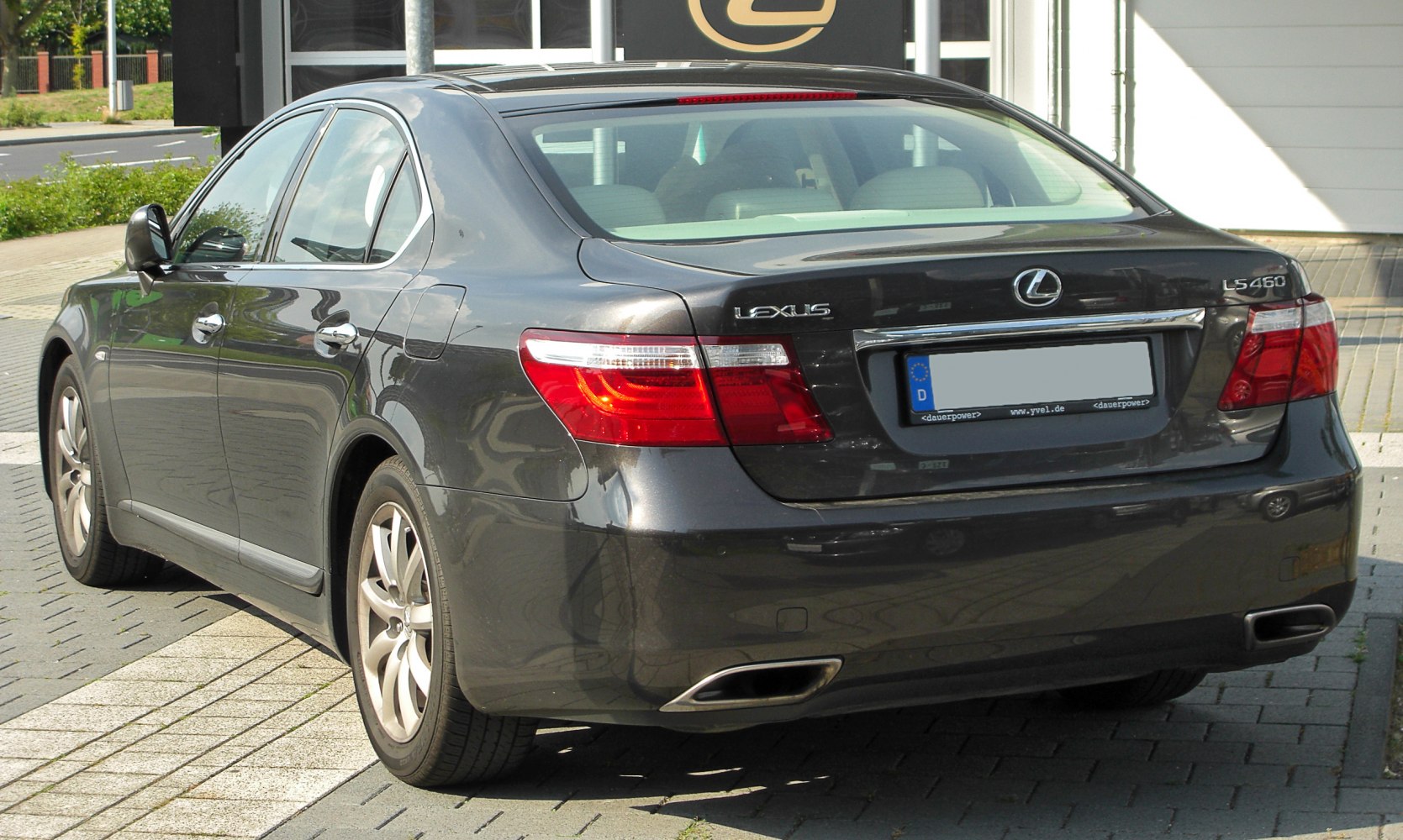 Rear view of a four-door luxury sedan showing exhaust tips and tail lights