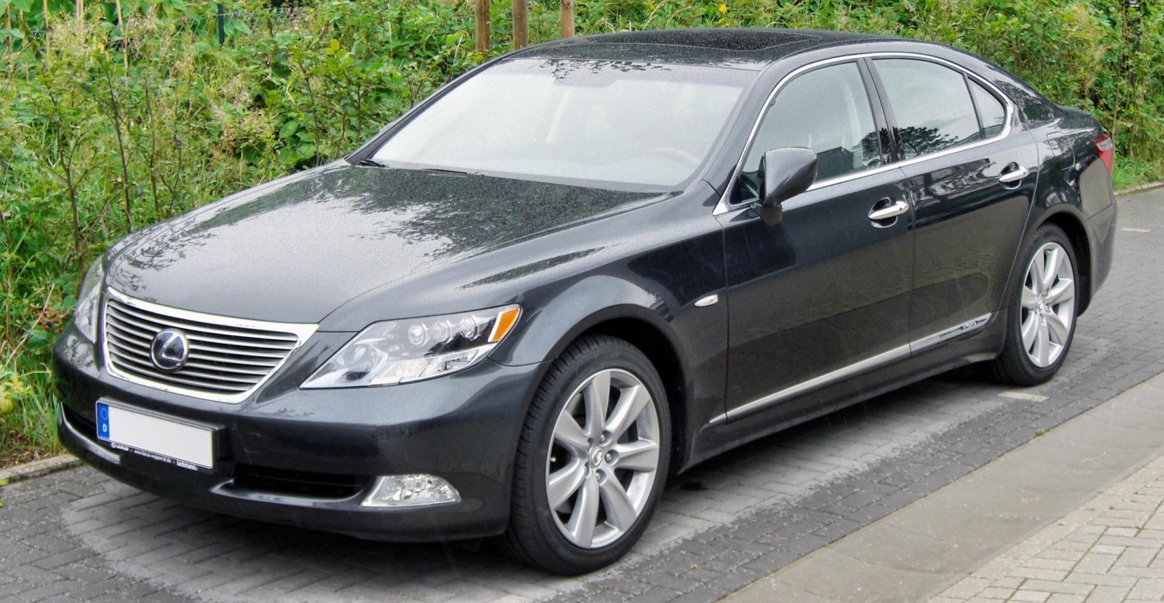 Black luxury sedan front-side with chrome grille and alloy wheels