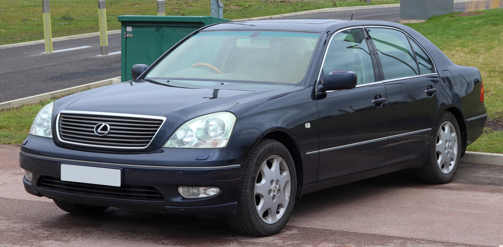 Front-side view of luxury sedan with distinctive headlights and grille.