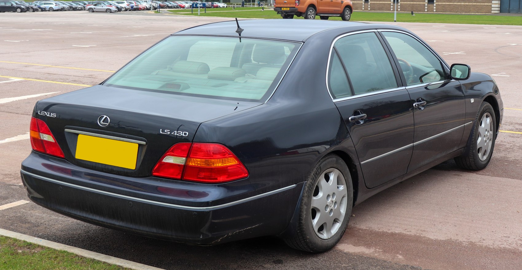 Rear and side view of a black luxury sedan with distinctive tail lights and chrome trim