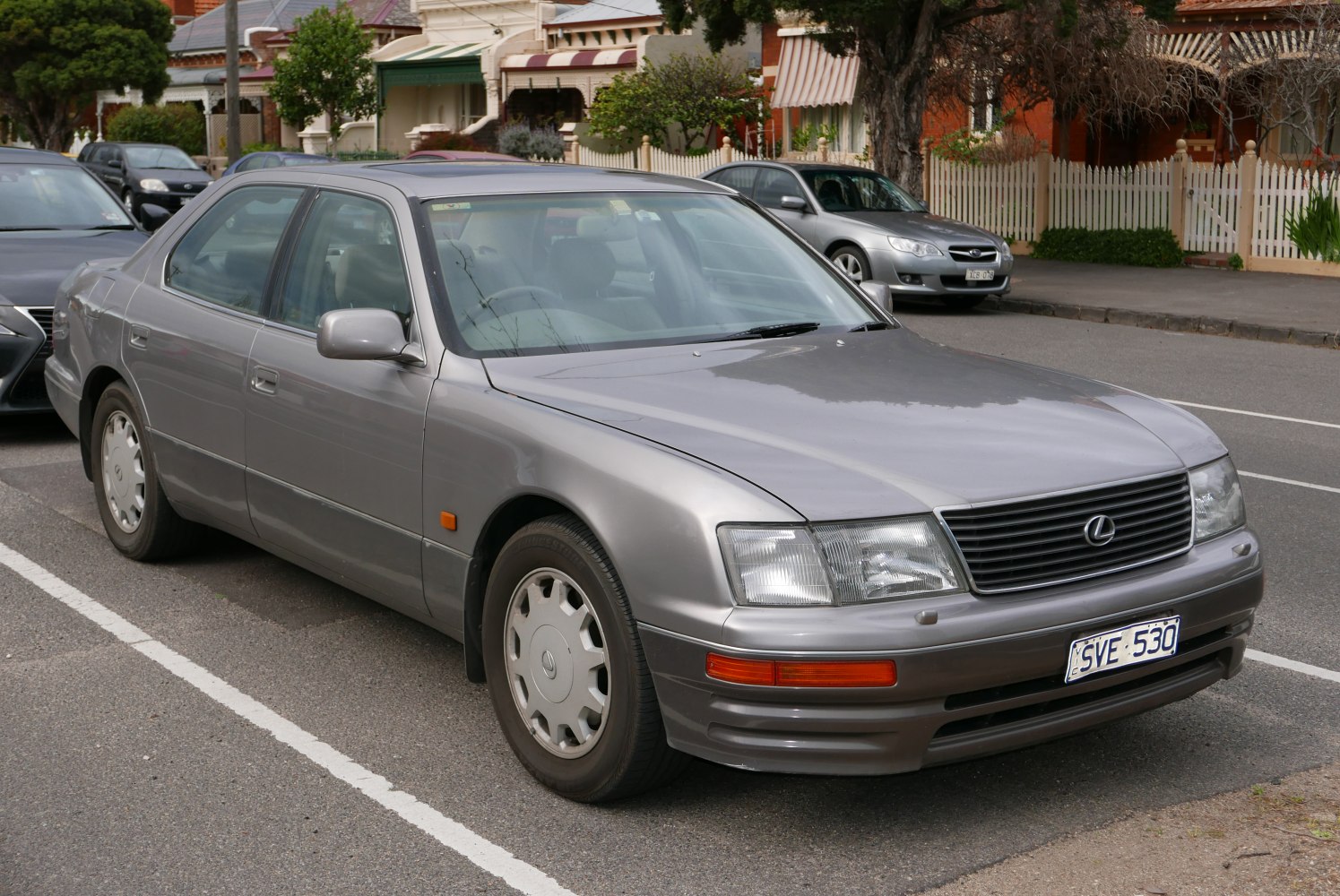 Silver mid-90s luxury sedan front 3/4 view with smooth body lines