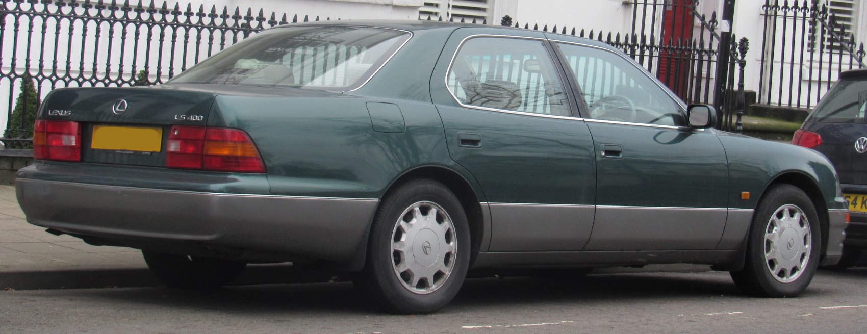 Rear and side profile of a two-tone luxury sedan with alloy wheels