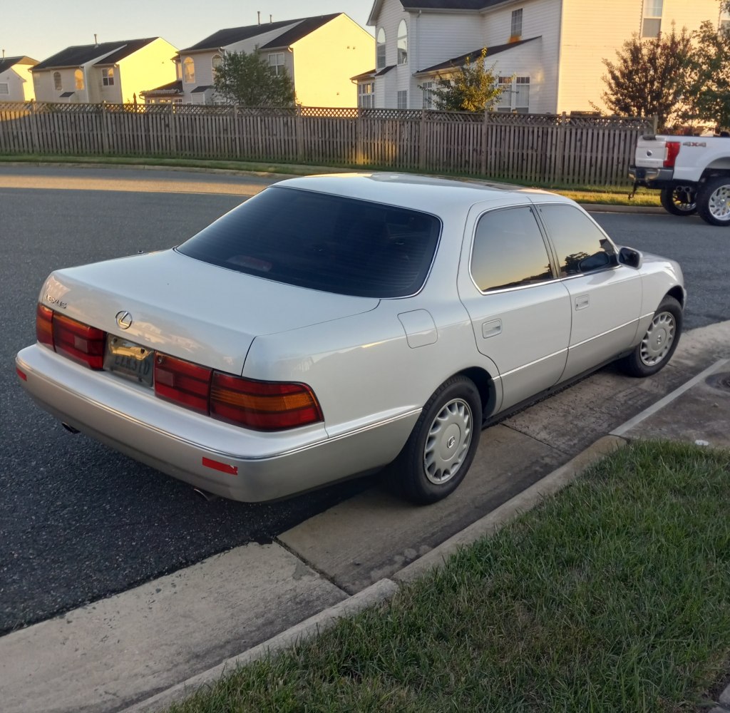 Rear and side view of a white luxury sedan with distinct taillights and four doors