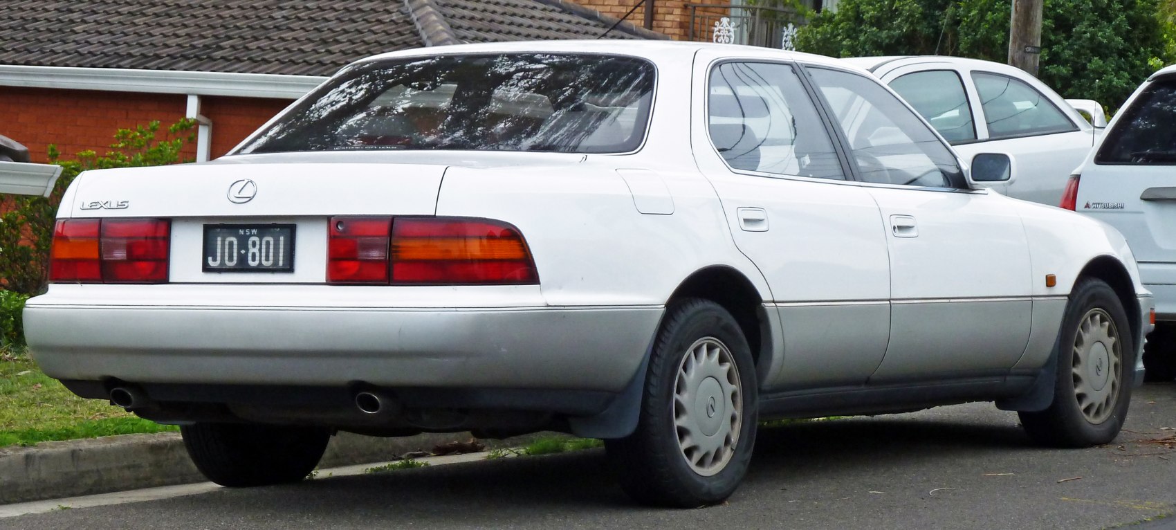 Rear view of a classic sedan with dual exhaust and rectangular tail lights