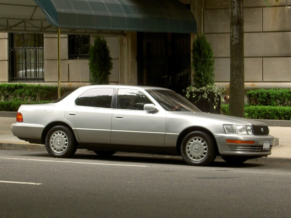 Side profile of a 1990 sedan with smooth lines and distinct wheel covers