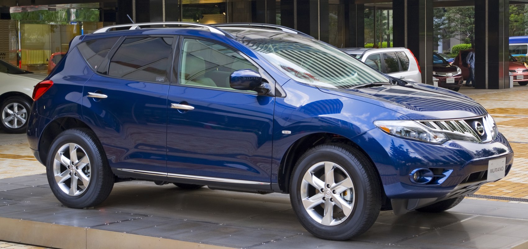 Blue SUV with alloy wheels, roof rails, and side view