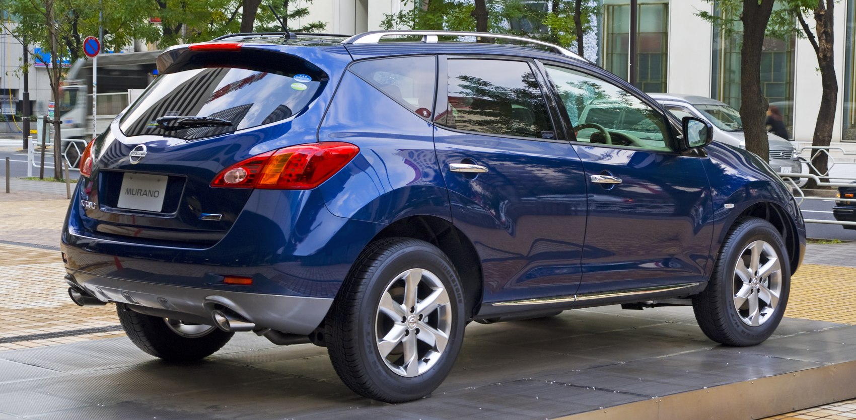 Rear side view of blue SUV with alloy wheels and roof rails