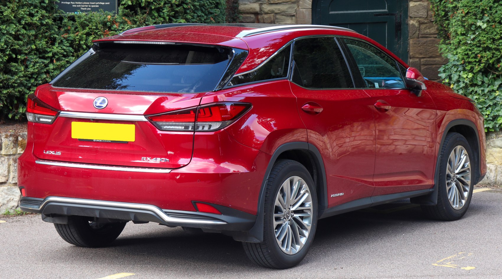 Red Lexus SUV rear view with hybrid badge and modern taillights