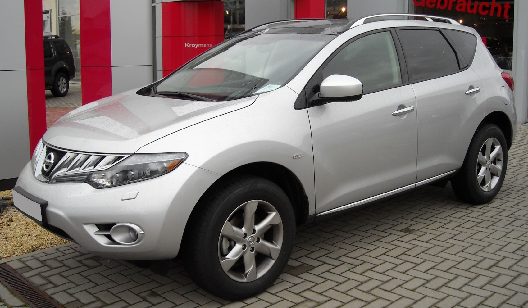 Silver SUV front-side view with chrome grille and roof rails