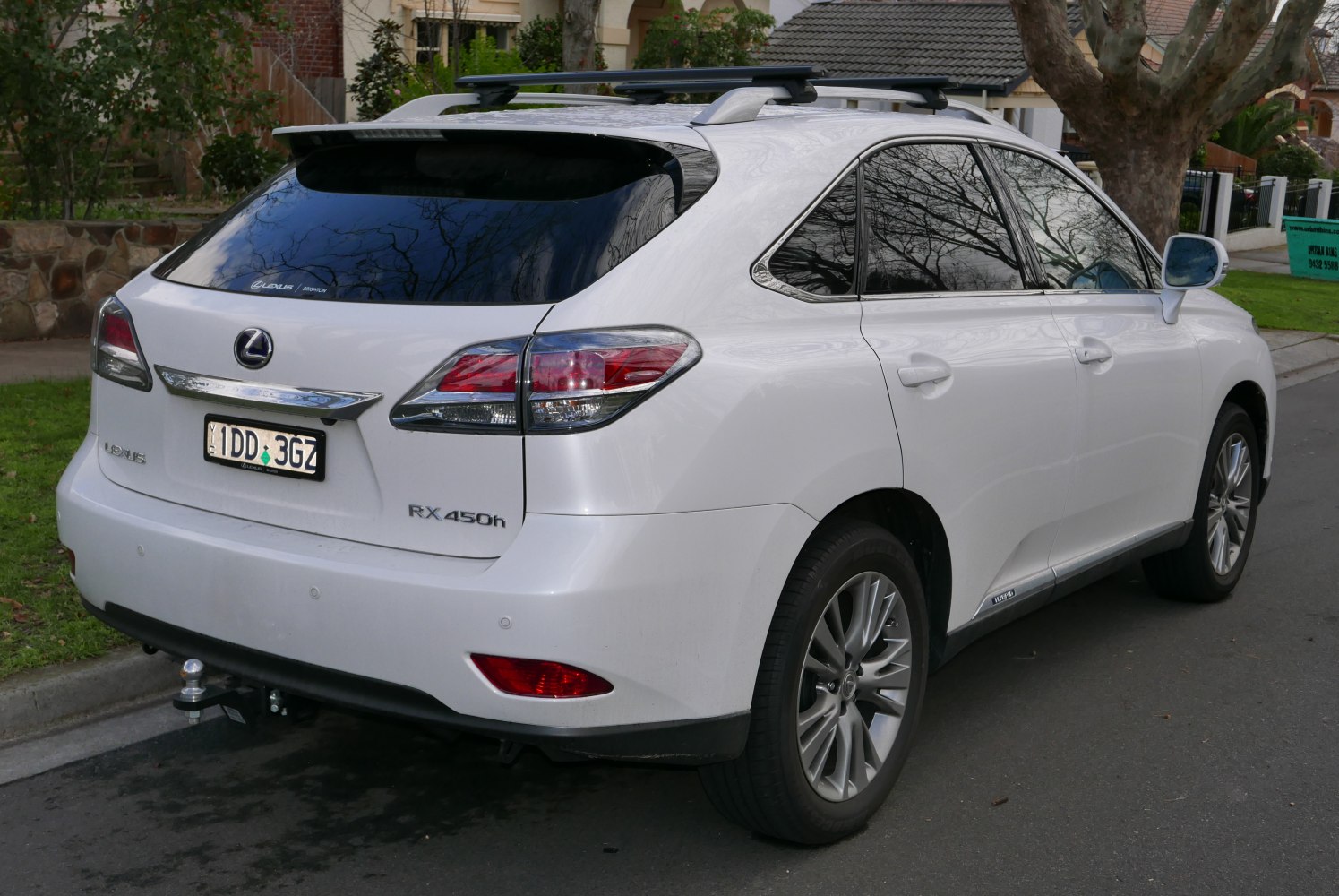 Rear view of hybrid SUV with roof rack and parking sensors.