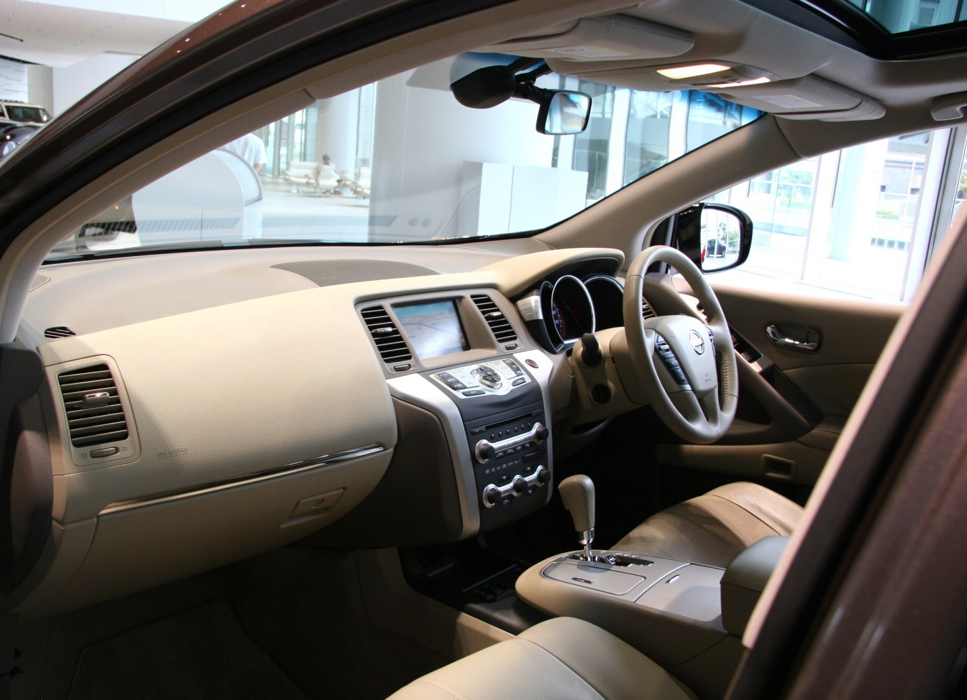 Beige car interior dashboard, steering wheel, and center console