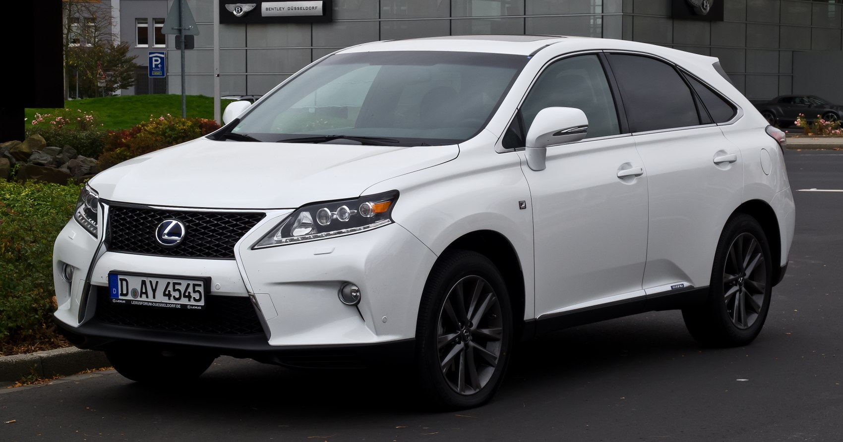 Front and side view of white SUV with spindle grille and sleek headlights
