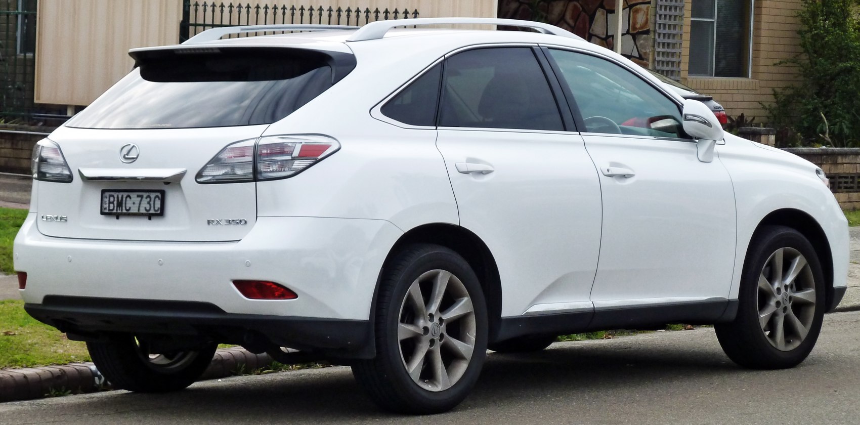Rear side view of white SUV with alloy wheels and tinted windows