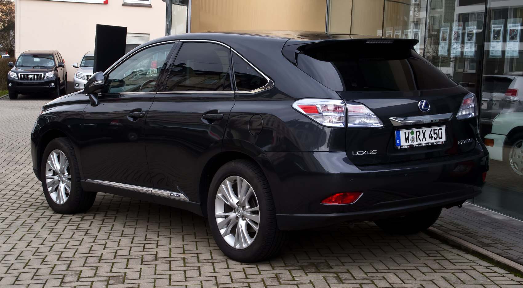 Rear side view of an SUV with alloy wheels and hybrid badge