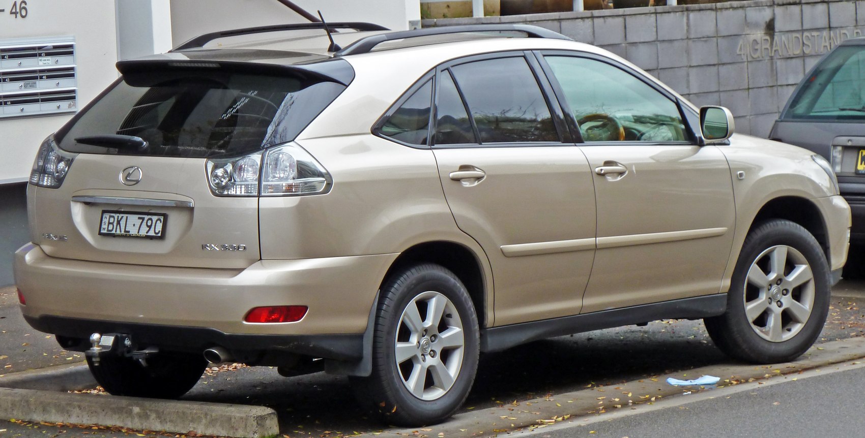 Beige SUV rear side with roof rails and tow hitch