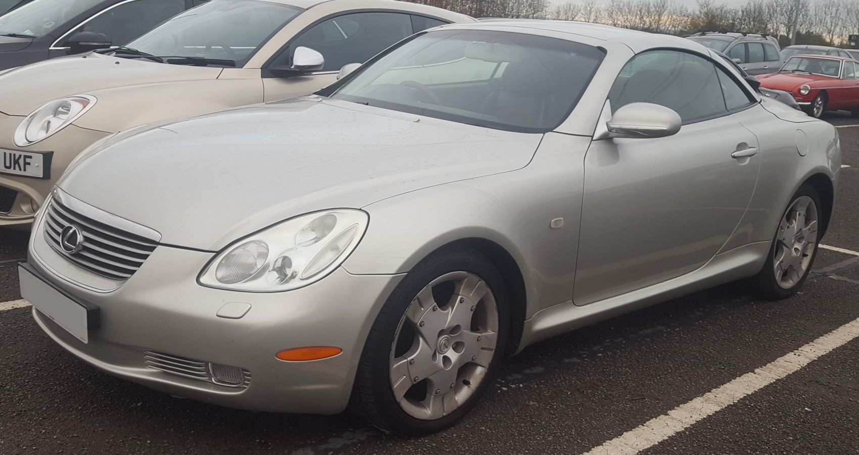 Silver convertible coupe with dual headlights and alloy wheels