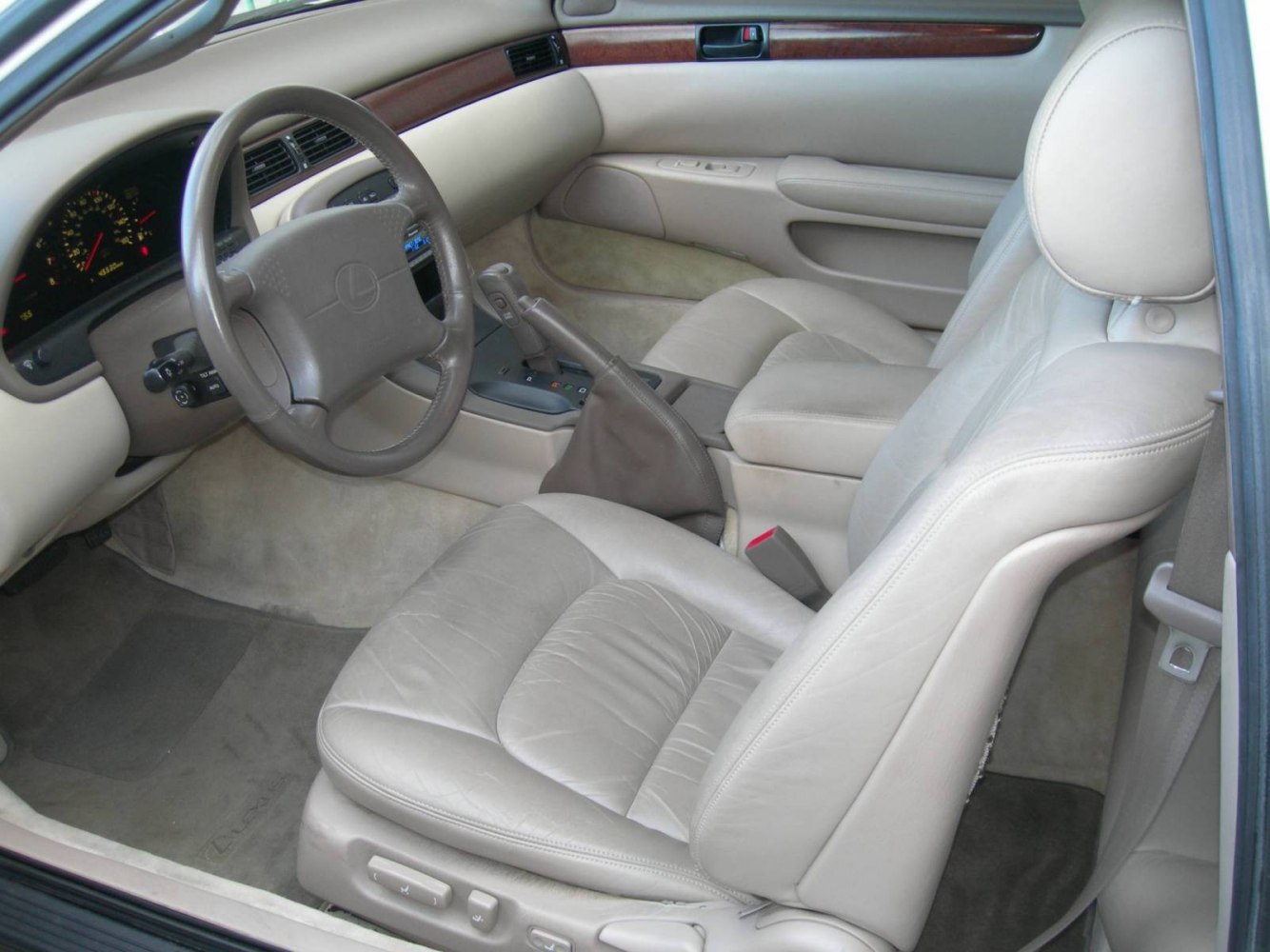 Leather seats and steering wheel in car interior close-up.